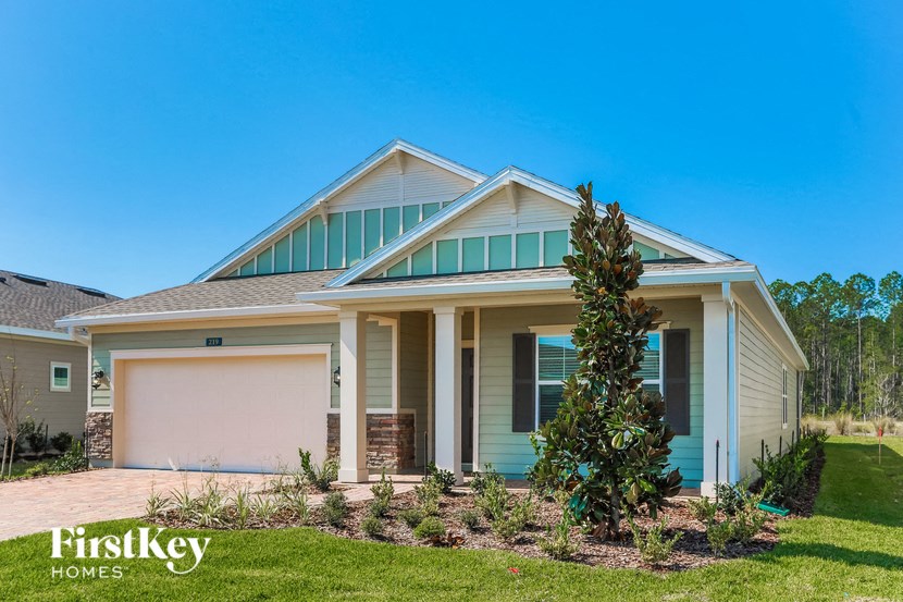 a house with a garage door and a lawn