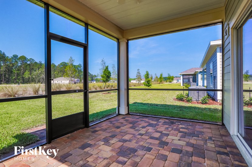 a screened porch with large windows overlooking the yard and grass
