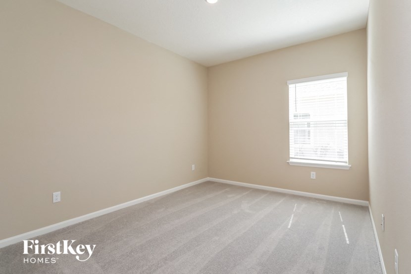 a bedroom with a carpeted floor and a window