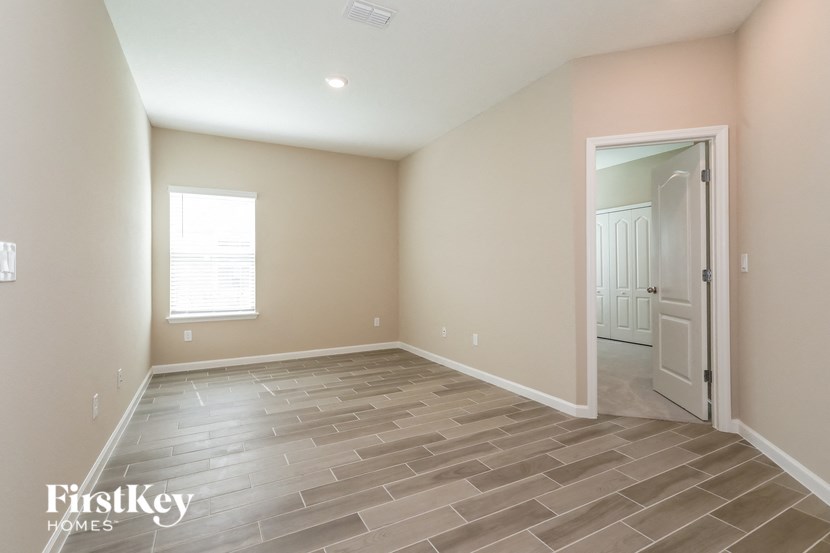 the spacious living room with tile flooring and a white door