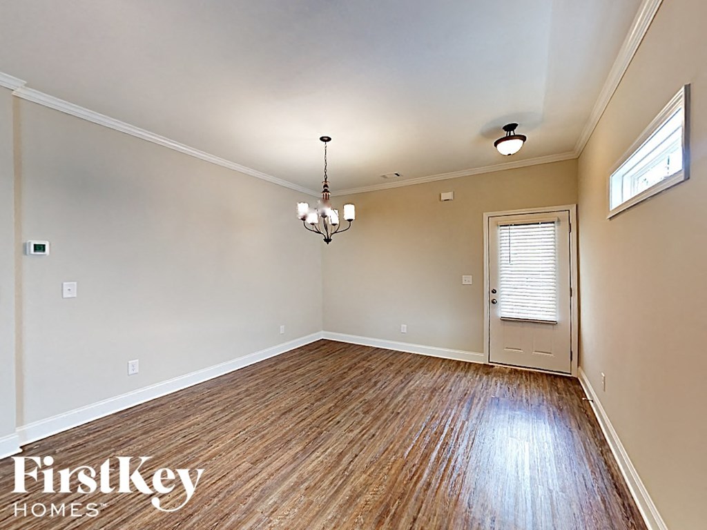 A room with wooden floors and a chandelier hanging from the ceiling.