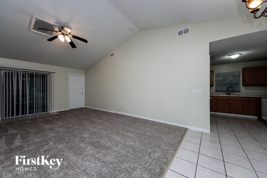 A room with a ceiling fan and a carpeted floor.