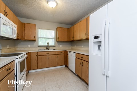 A kitchen with wooden cabinets and a white refrigerator.