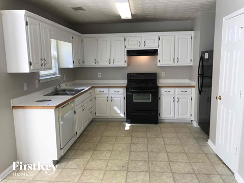 A kitchen with white cabinets and a black oven.