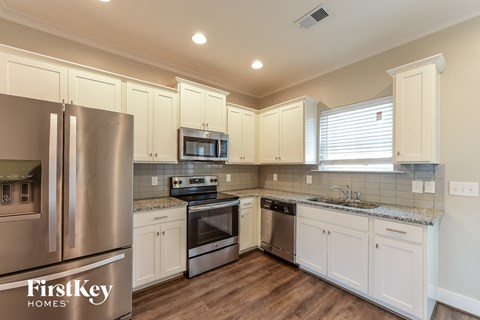 a kitchen with white cabinets and stainless steel appliances