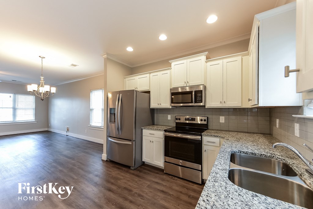 a kitchen with white cabinets and stainless steel appliances