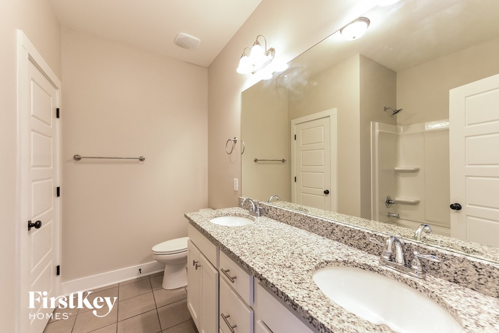 a bathroom with two sinks and a toilet and a mirror