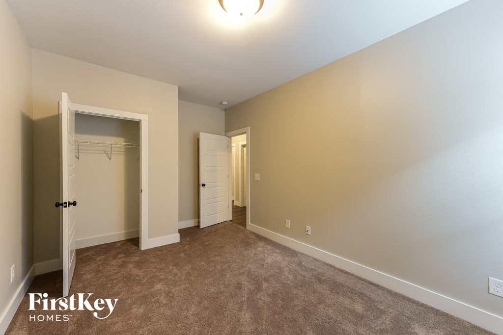 a bedroom with a closet and a door to the bathroom