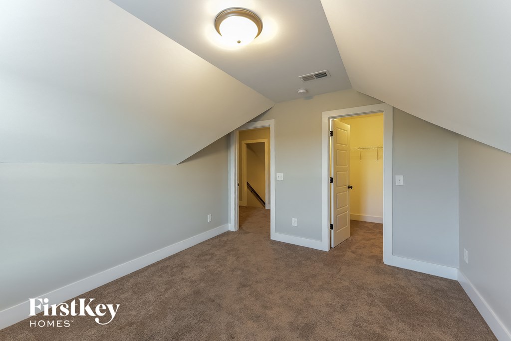 a bedroom with a carpeted floor and a door to a closet