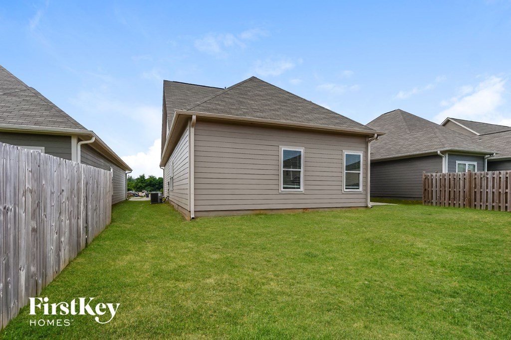 the backyard of a house with a yard and a fence