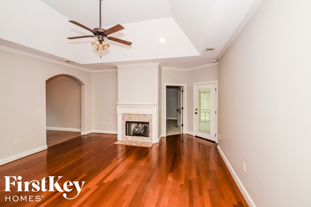a living room with a fireplace and a ceiling fan