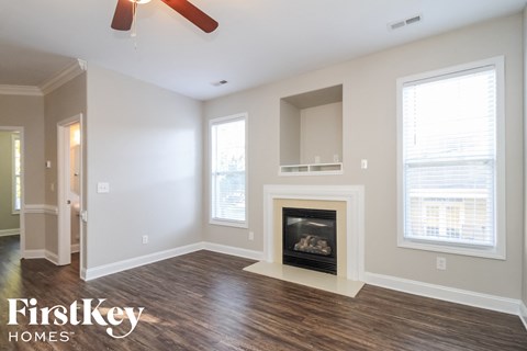 a living room with a fireplace and a ceiling fan