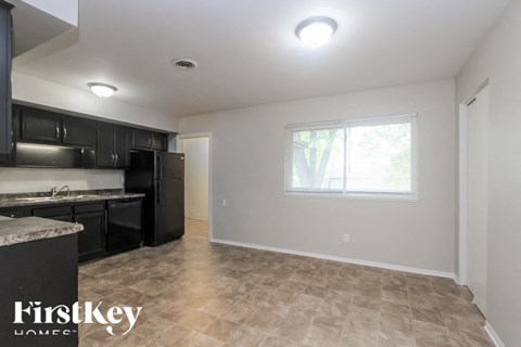 A kitchen with black cabinets and a marble countertop.