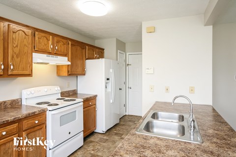 A kitchen with a stove top oven and a refrigerator.