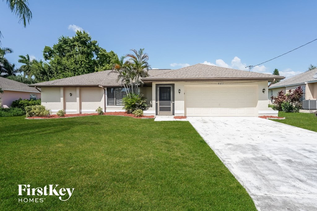 a white house with a lawn and a driveway