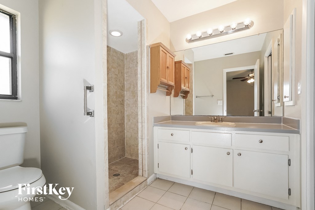 a bathroom with a sink and a shower and a mirror
