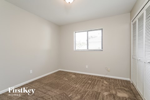 a spacious living room with carpet and a window