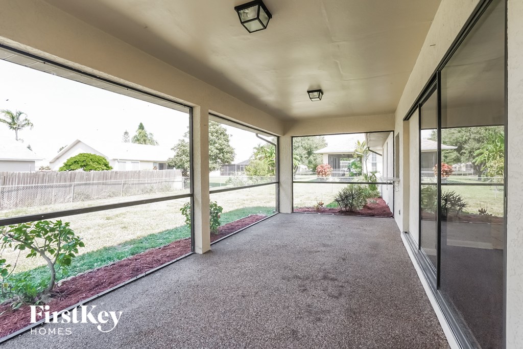 a covered patio with large windows on the side of a house