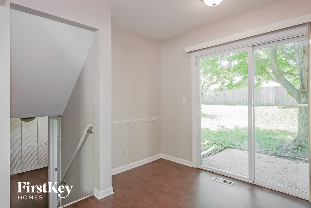 A room with a sliding glass door leading to a backyard.