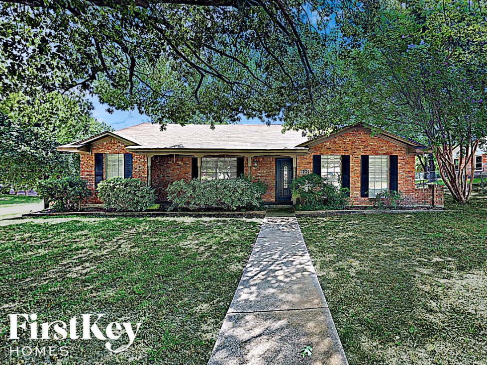 A brick house with a tree in front of it.