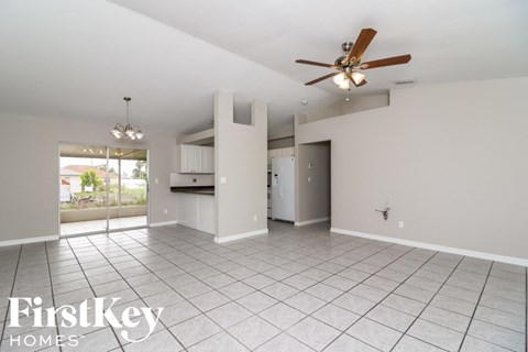 A spacious room with a ceiling fan and tiled flooring.