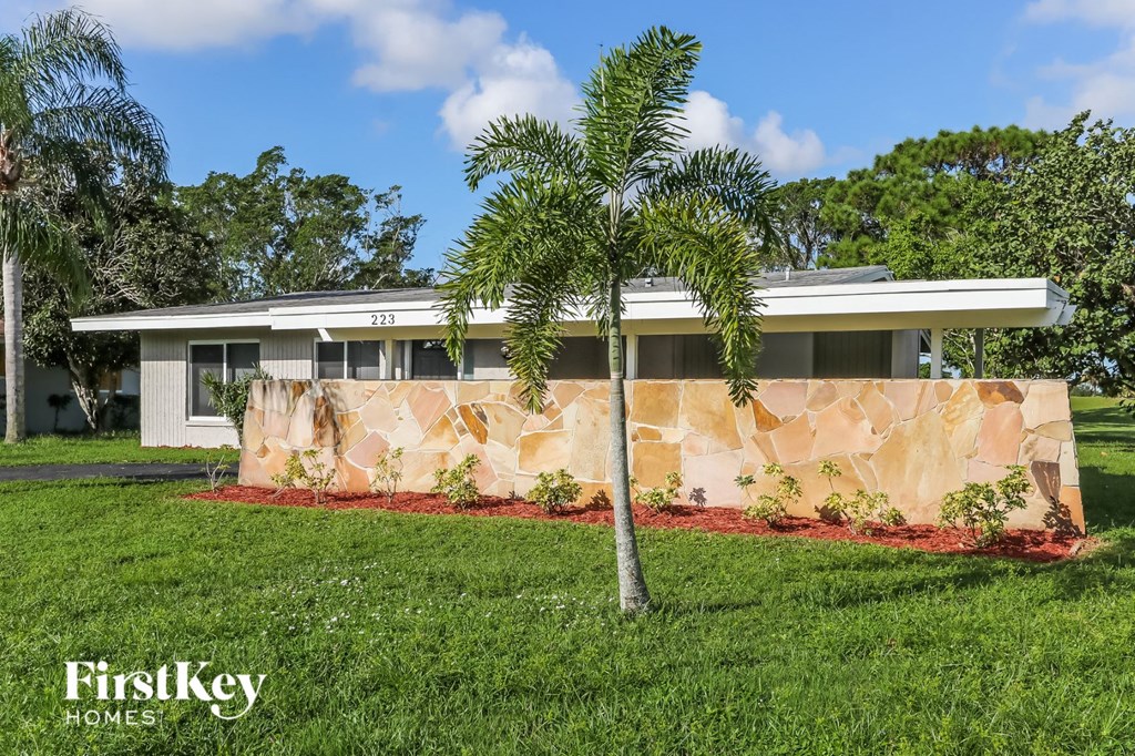 a home with palm trees in front of it