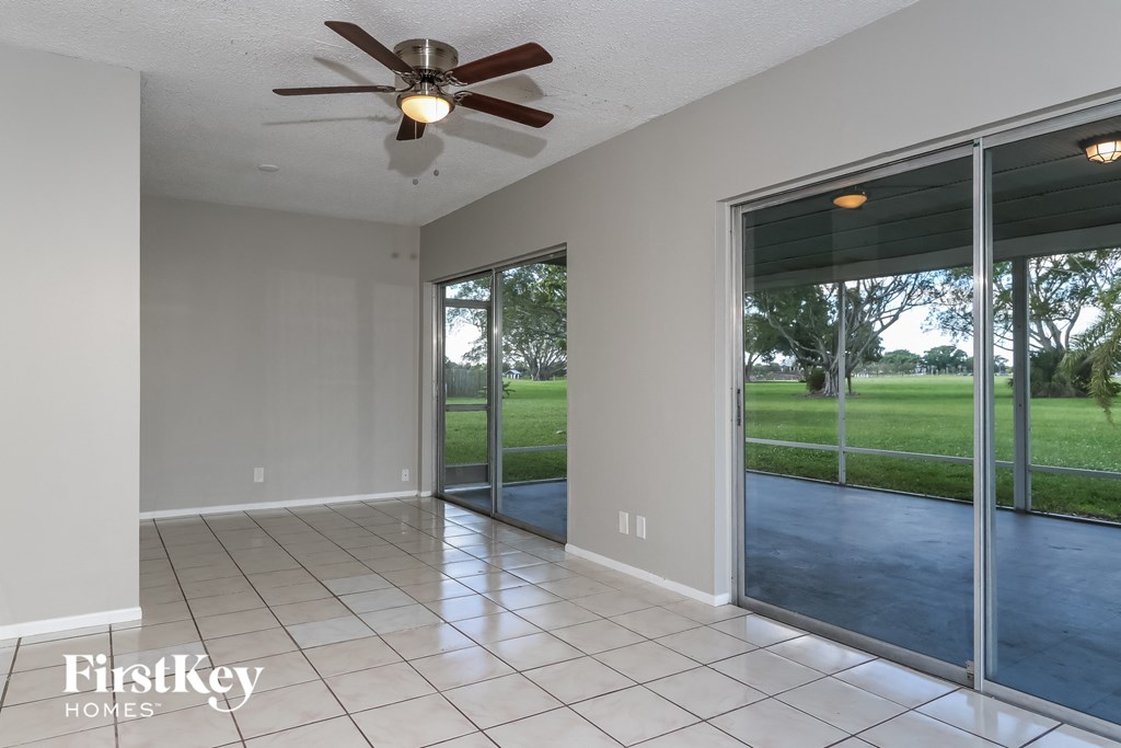 a living room with sliding glass doors and a ceiling fan