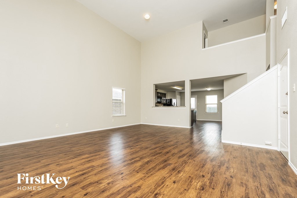 a living room with a hard wood floor and white walls