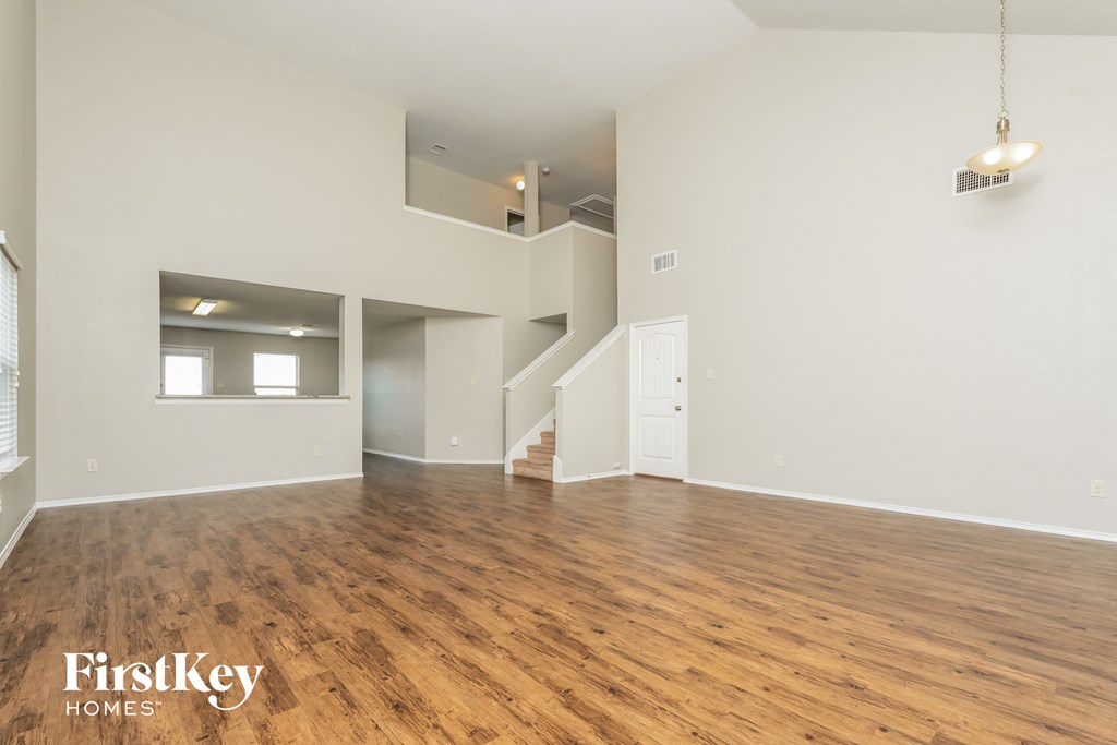 a living room with a hard wood floor and white walls