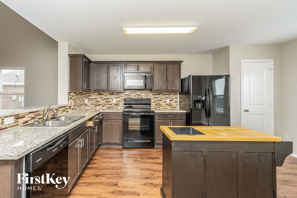 a kitchen with dark wood cabinets and stainless steel appliances and a counter top