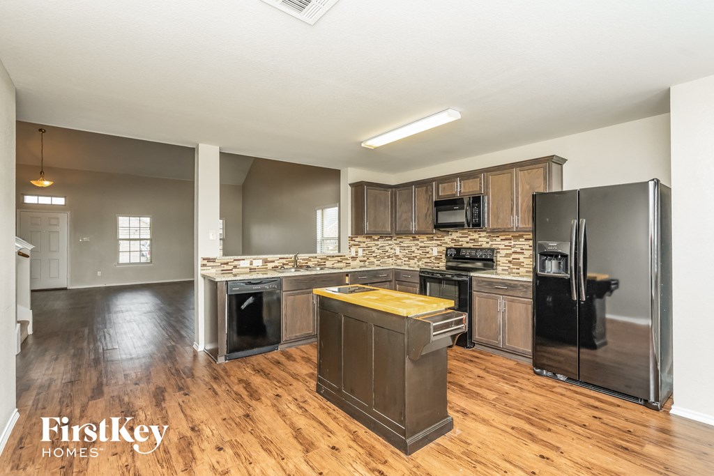a kitchen with stainless steel appliances and wood flooring