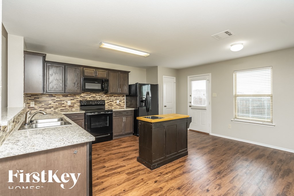 a kitchen with wood flooring and a granite counter top