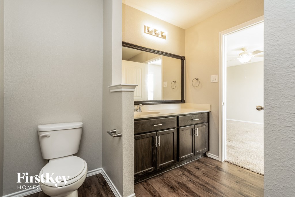 a bathroom with a toilet and a sink and a mirror