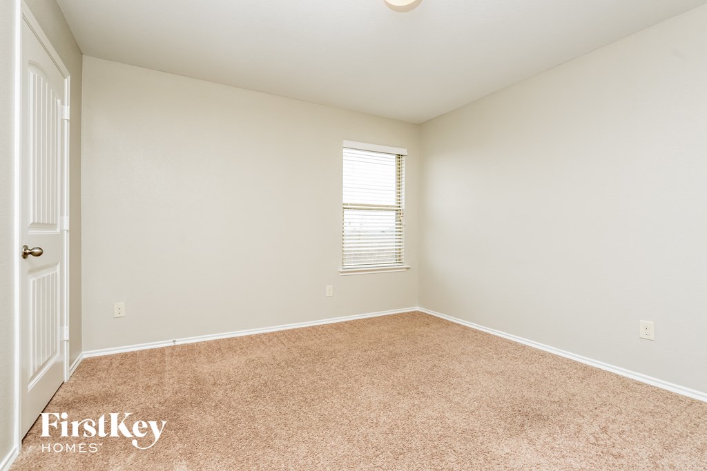 a spacious room with carpet and a window