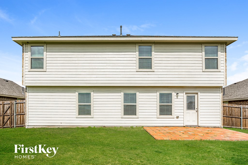 a white house with white siding and green grass