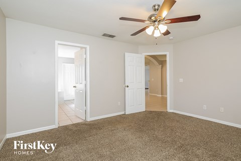 a living room with carpet and a ceiling fan