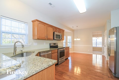 A kitchen with wooden cabinets and granite countertops.