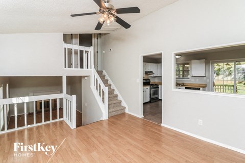A spacious living room with a staircase leading to the upper floor.