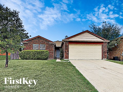 a small brick house with a garage and a driveway