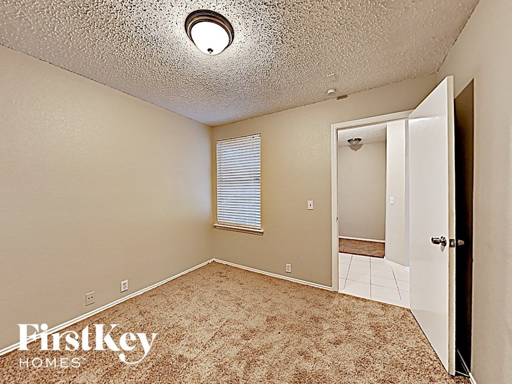 an empty room with a door to a bathroom and a closet