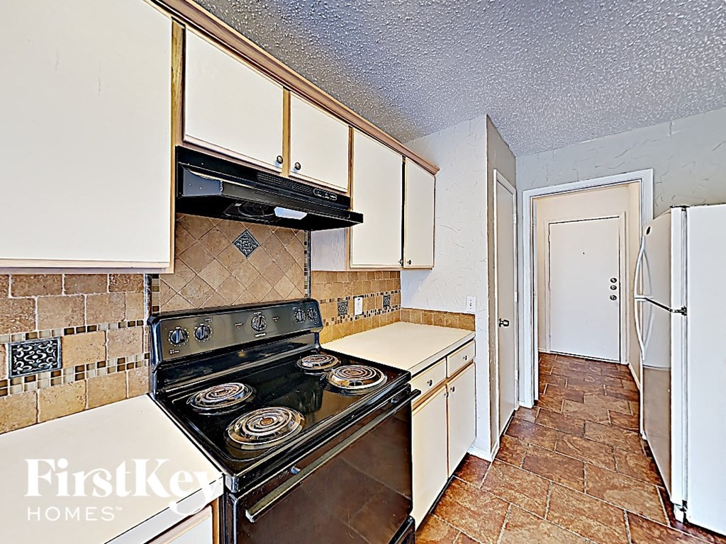 a kitchen with white cabinets and a stove and a refrigerator