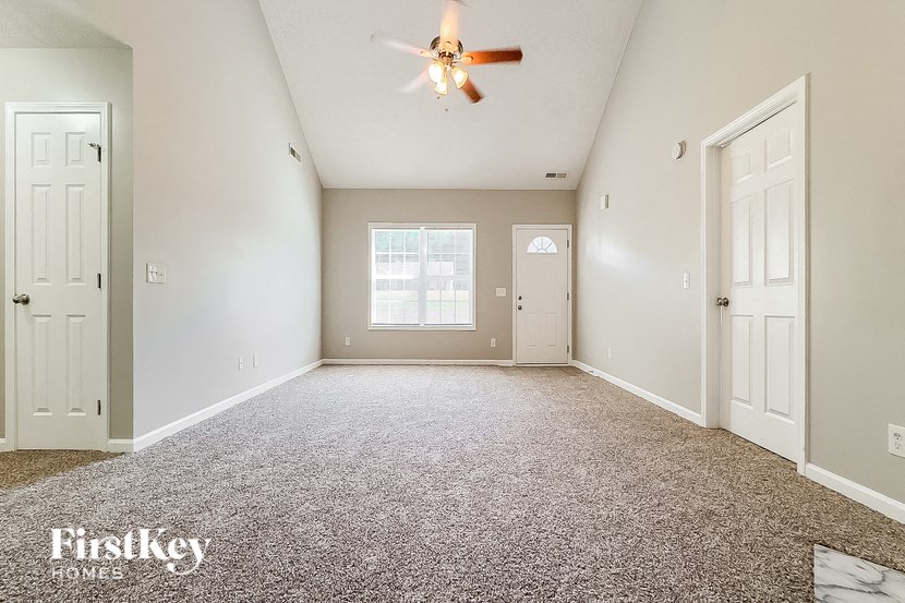 an empty room with a ceiling fan and a white door