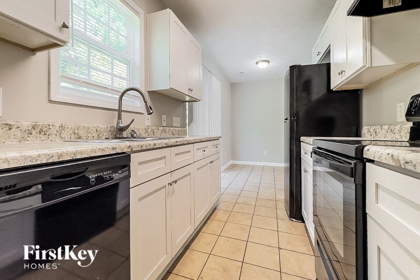 a kitchen with a stove and a sink and a refrigerator