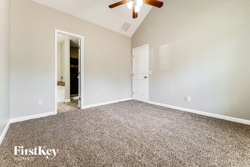 an empty room with a ceiling fan and a white door