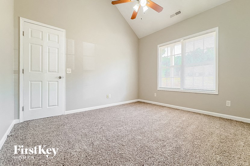 an empty room with a ceiling fan and a white door