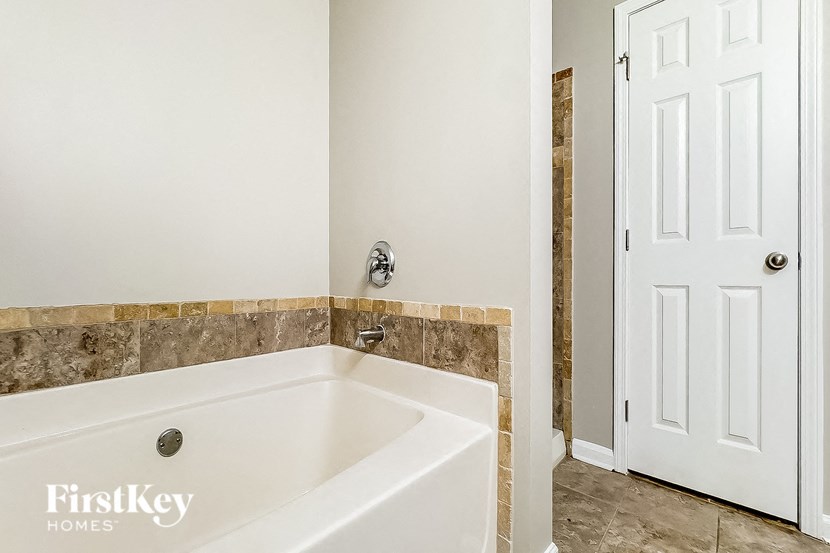 a bath tub in a bathroom with a white door