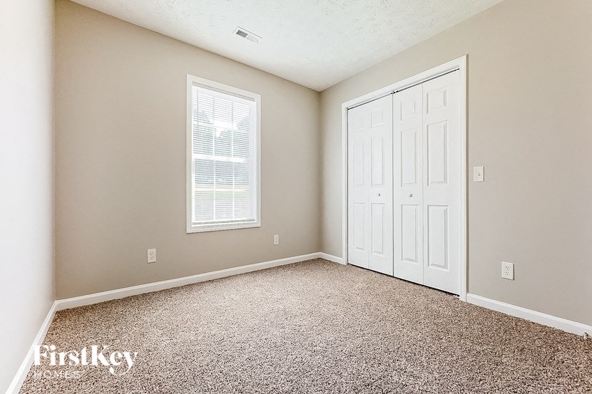 an empty room with a white door and a window