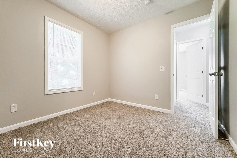 an empty room with a white door and a window