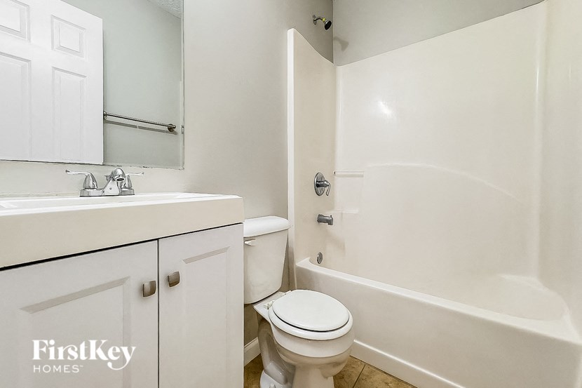 a white bathroom with a toilet and a sink