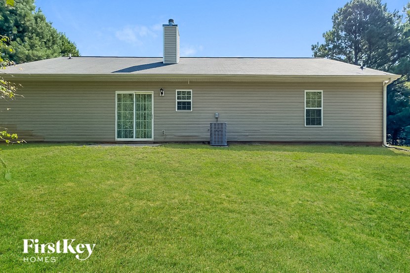 a white house with a grassy yard and a tree